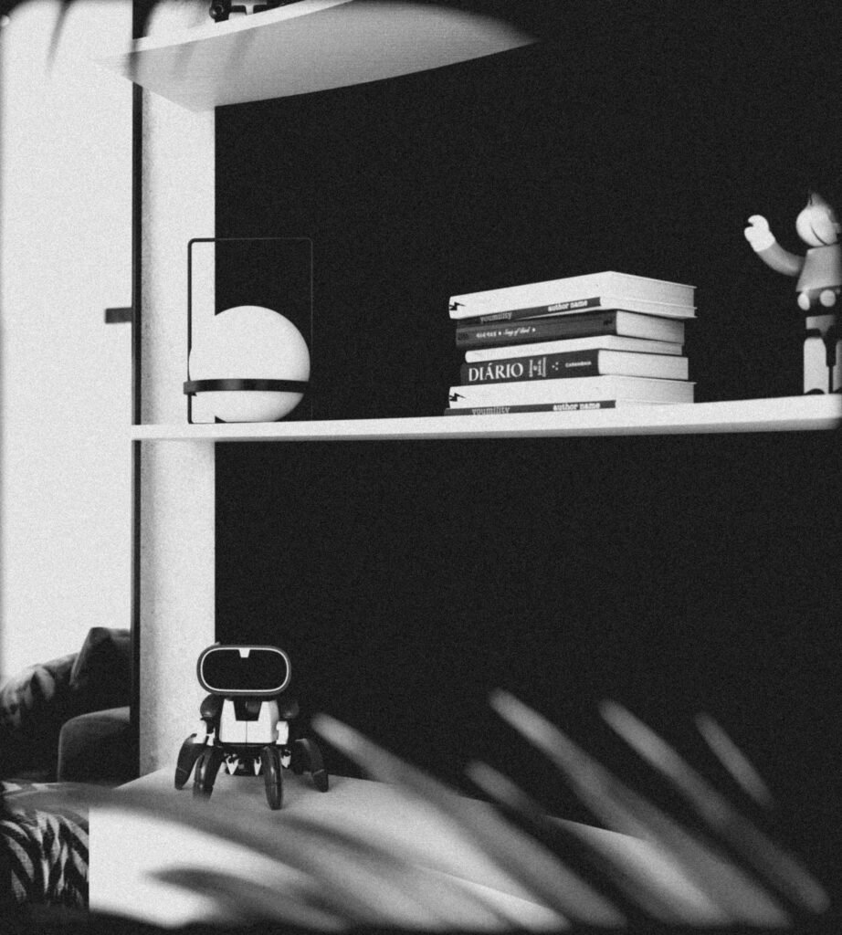 A monochrome desk setup with a figure and books , representing the human-led problem framing that machines cannot replicate.
