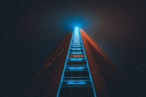 A surreal image of a glowing wooden ladder reaching upward into a dark blue sky with bright light at the top, representing a road to skills that pay forever.