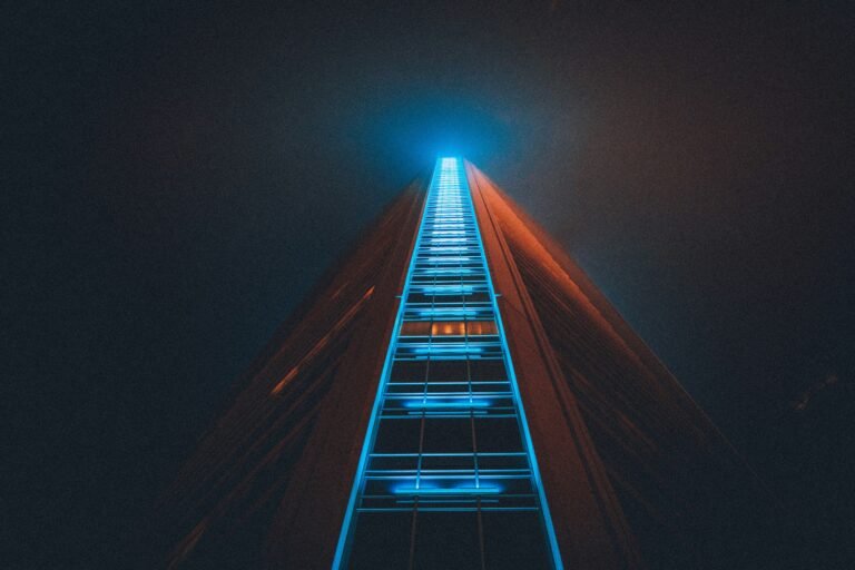 A surreal image of a glowing wooden ladder reaching upward into a dark blue sky with bright light at the top, representing a road to skills that pay forever.